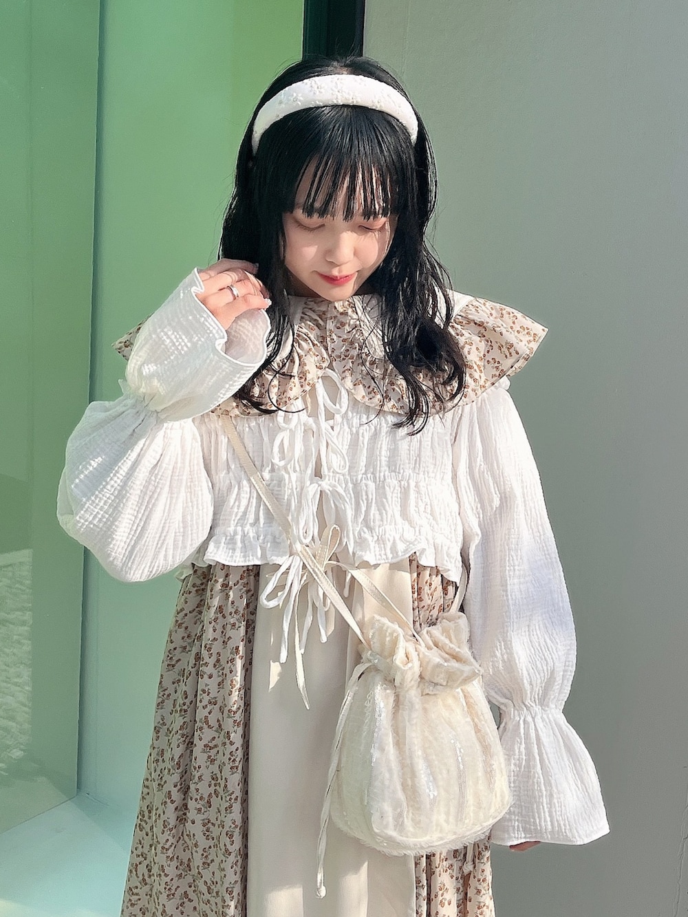 ベージュ系のワンピース、ホワイト系のシャツ/ブラウス、ホワイト系のショルダーバッグを着用したレディースの冬コーディネートの5枚目の写真