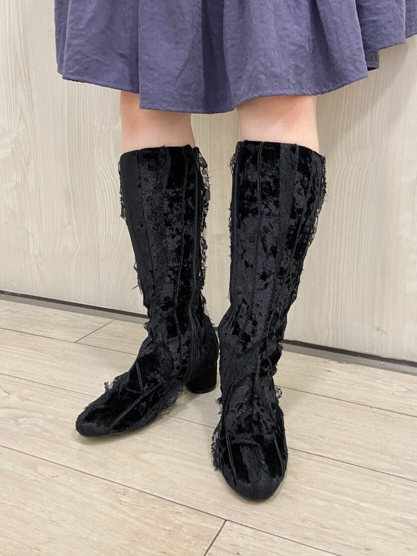 ブルー系のナイロンジャケット、パープル系のワンピース、ブラック系のブーツを着用したレディースの冬コーディネートの7枚目の写真