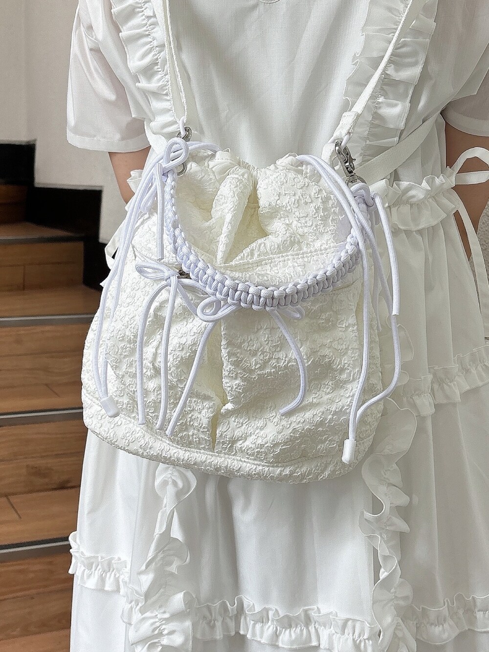 ホワイト系のスニーカー、ホワイト系のワンピース、ホワイト系のショルダーバッグを着用したレディースの夏コーディネートの8枚目の写真