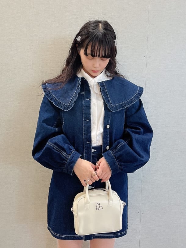 ブルー系のデニムジャケット、ホワイト系のブーツ、ホワイト系のボストンバッグを着用したレディースの夏コーディネートの4枚目の写真
