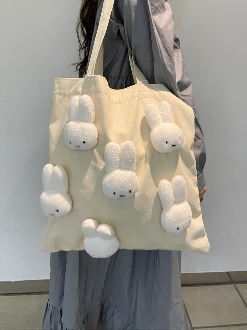 ブルー系のワンピース、ホワイト系のスニーカー、ホワイト系のトートバッグを着用したレディースの冬コーディネートの5枚目の写真
