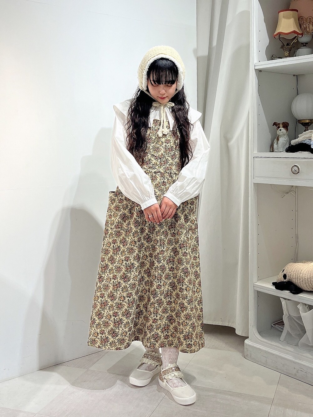 ホワイト系のシャツ/ブラウス、ベージュ系のジャンパースカート、ホワイト系のスニーカーを着用したレディースの秋コーディネートの3枚目の写真