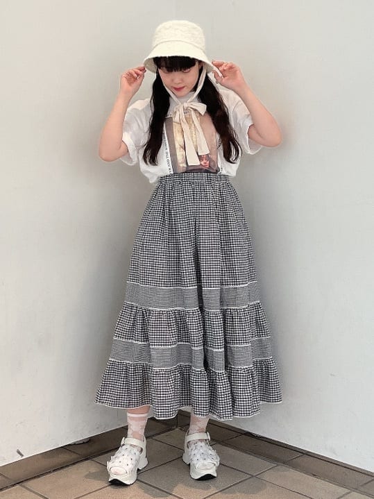 ホワイト系のサンダル、ホワイト系のTシャツ/カットソー、ブラック系のスカートを着用したレディースの夏コーディネートの2枚目の写真