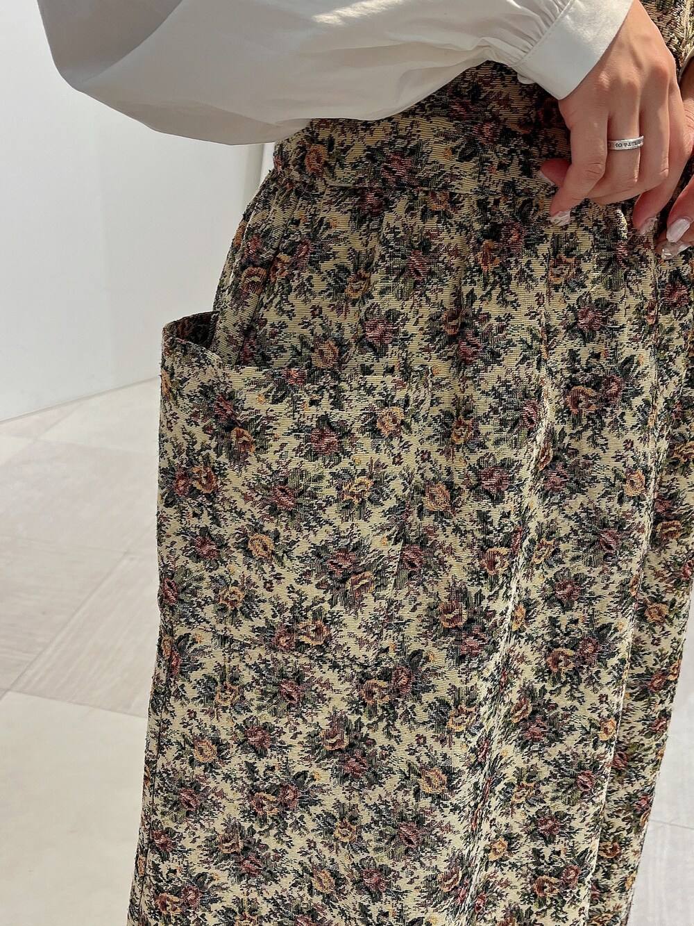 ホワイト系のシャツ/ブラウス、ベージュ系のジャンパースカート、ホワイト系のスニーカーを着用したレディースの秋コーディネートの8枚目の写真