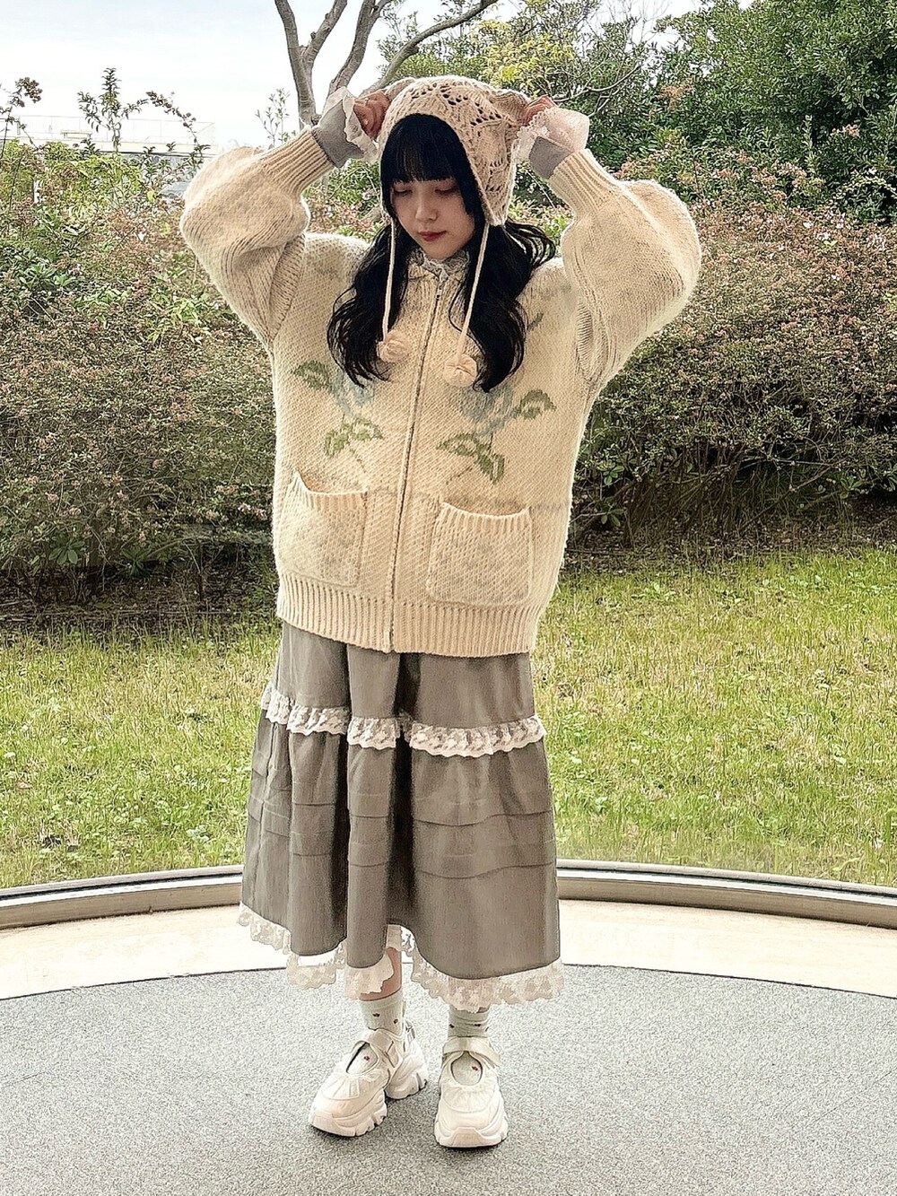 ブルー系のカーディガン/ボレロ、グレー系のニット/セーター、グレー系のスカートを着用したレディースの冬コーディネートの2枚目の写真