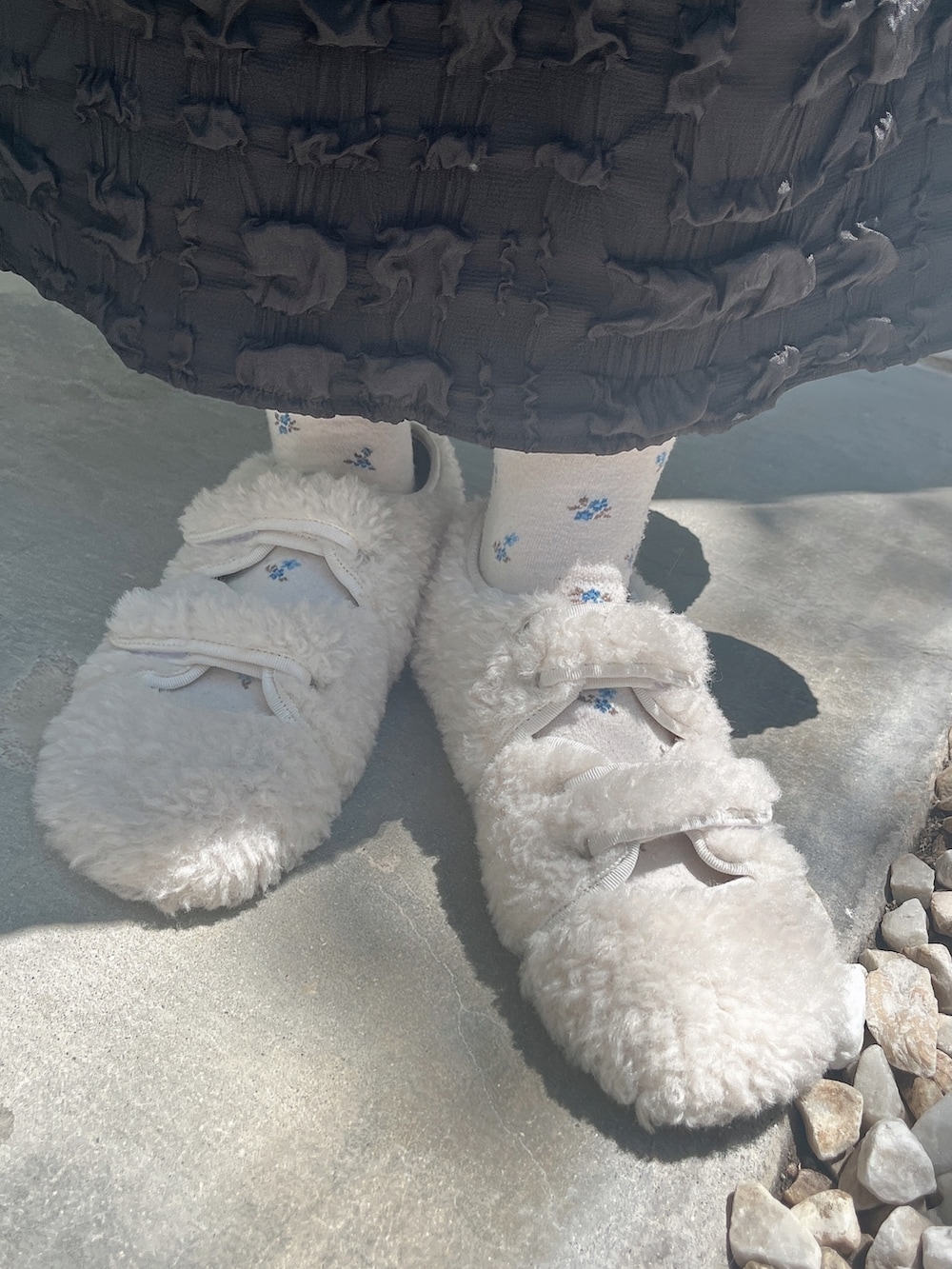 ブルー系のニット/セーター、ブラック系のワンピース、ホワイト系のスリッポンを着用したレディースの夏コーディネートの9枚目の写真