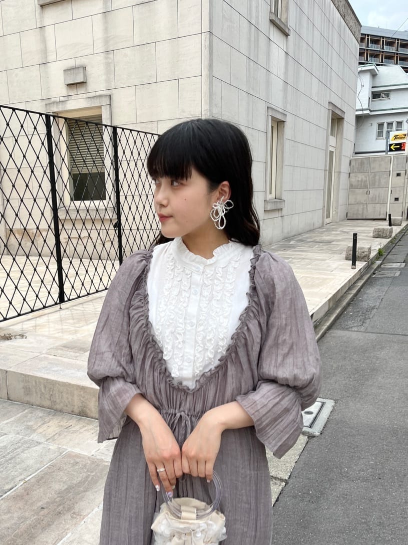 ホワイト系のパンプス、ホワイト系のハンドバッグ、グレー系のワンピースを着用したレディースの春コーディネートの4枚目の写真