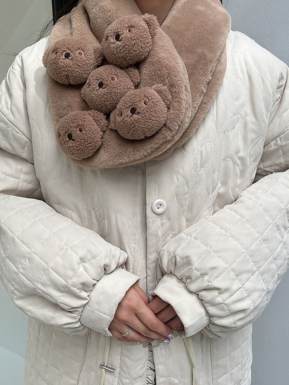 ホワイト系のシャツ/ブラウス、ホワイト系のブルゾン、グリーン系のジャンパースカートを着用したレディースの冬コーディネートの7枚目の写真