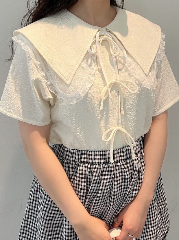 ホワイト系のシャツ/ブラウス、ホワイト系のスニーカー、ブラック系のスカートを着用したレディースの夏コーディネートの3枚目の写真