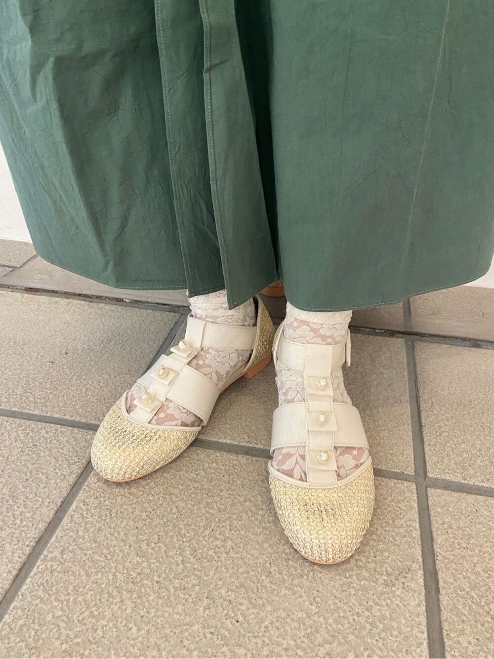 ベージュ系のパンプス、グリーン系のワンピース、ホワイト系のチュニックを着用したレディースの夏コーディネートの6枚目の写真