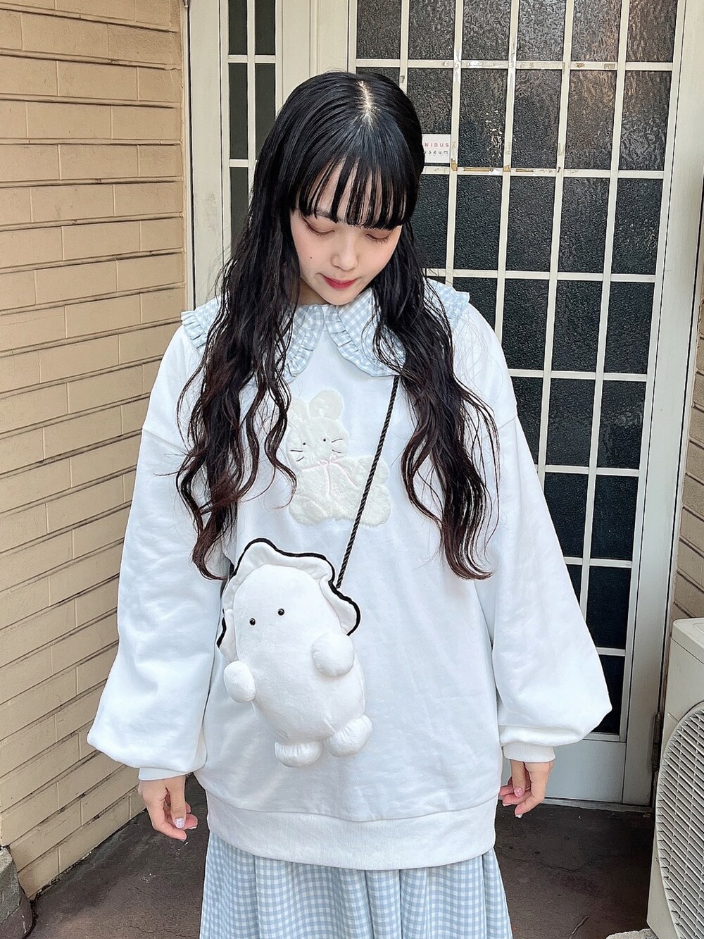 ホワイト系のスウェット、ホワイト系のショルダーバッグ、ブルー系のワンピースを着用したレディースの冬コーディネートの6枚目の写真