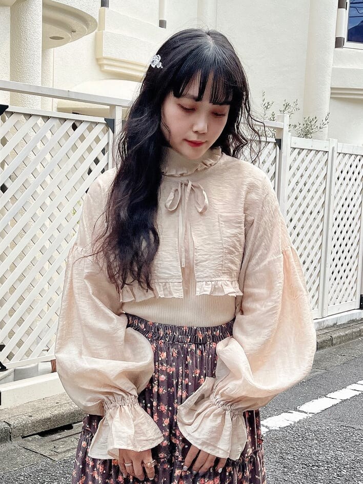 ブラウン系のスカート、ホワイト系のニット/セーター、ベージュ系のシャツ/ブラウスを着用したレディースの秋コーディネートの3枚目の写真