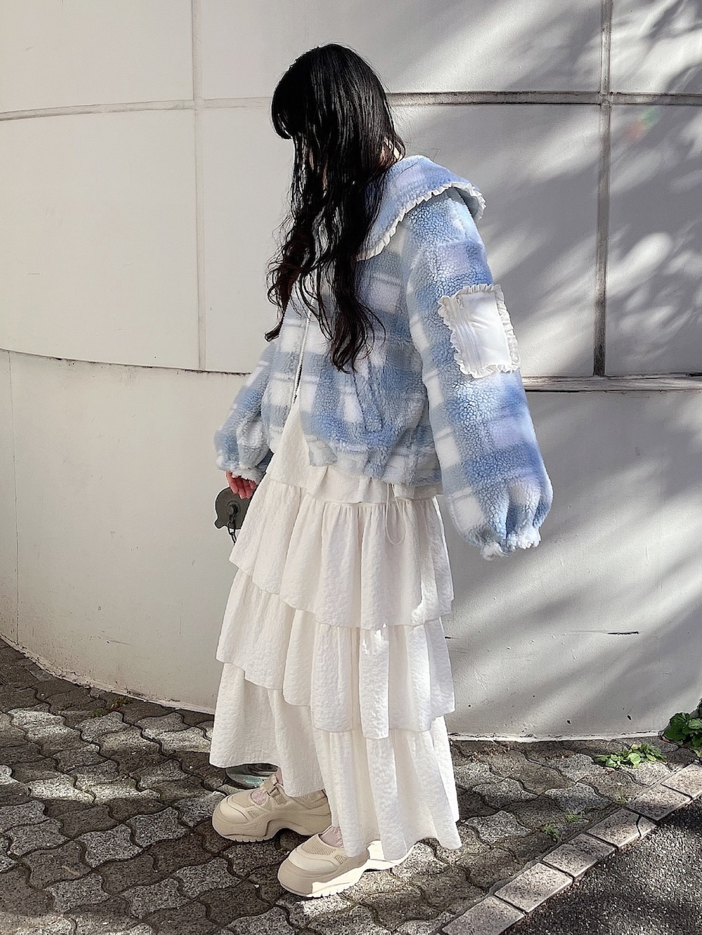 ホワイト系のスウェット、ブルー系のブルゾン、ホワイト系のスカートを着用したレディースの冬コーディネートの3枚目の写真