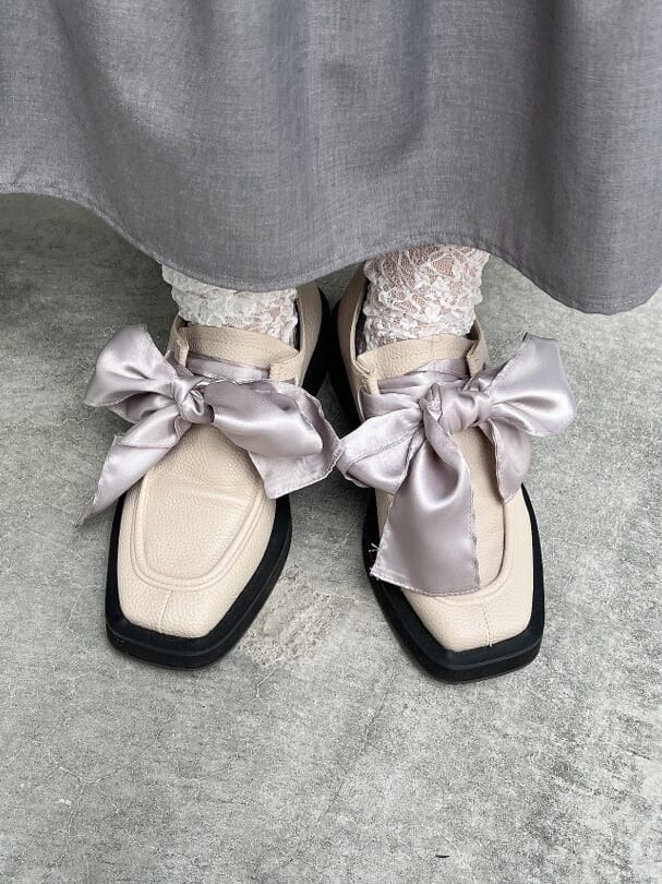 グリーン系のノーカラーコート、ホワイト系のシャツ/ブラウス、ホワイト系のモカシン/デッキシューズを着用したレディースの秋コーディネートの7枚目の写真