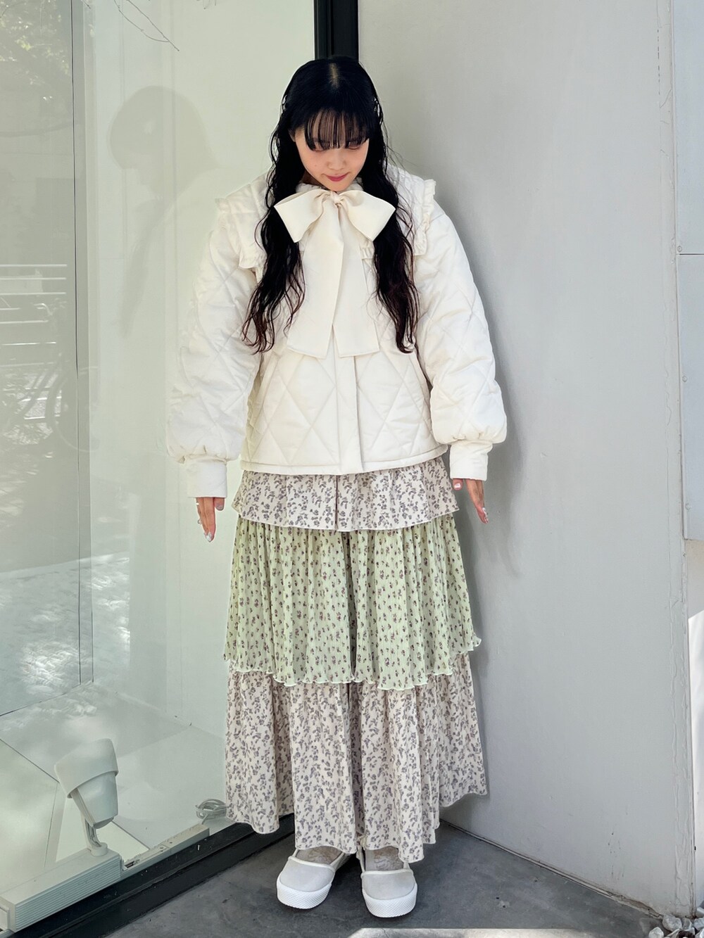 ホワイト系のダウンジャケット/コート、グリーン系のスカート、ホワイト系のスニーカーを着用したレディースの冬コーディネートの2枚目の写真