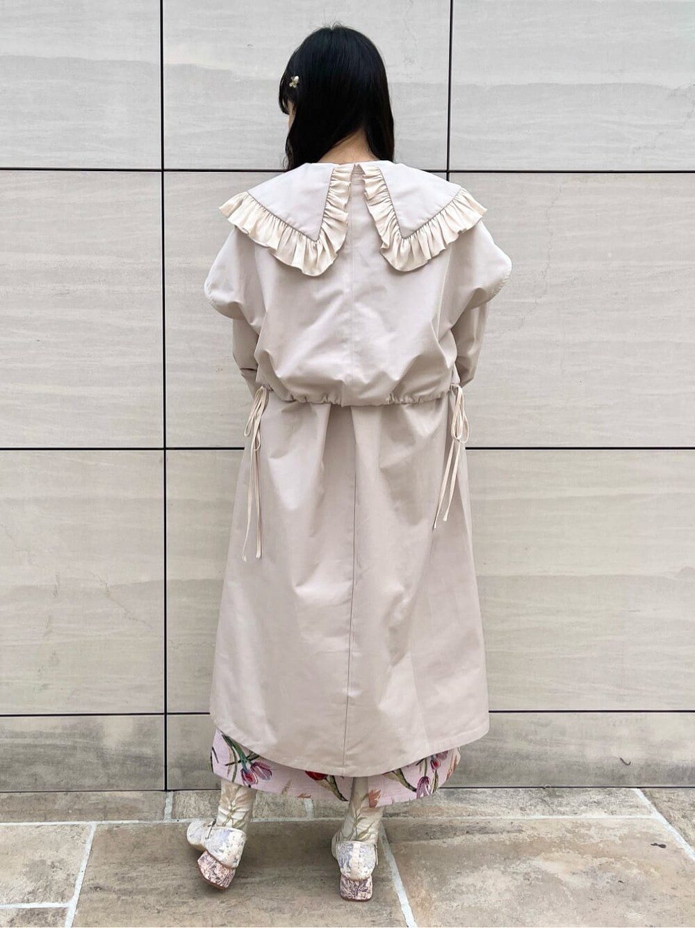 ホワイト系のシャツ/ブラウス、ホワイト系のトレンチコート、ピンク系のジャンパースカートを着用したレディースの冬コーディネートの2枚目の写真