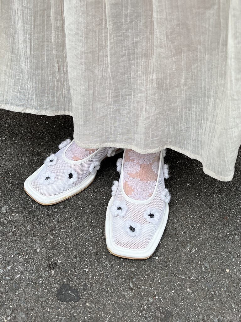ホワイト系のワンピース、ホワイト系のパンプス、パープル系のチュニックを着用したレディースの秋コーディネートの3枚目の写真