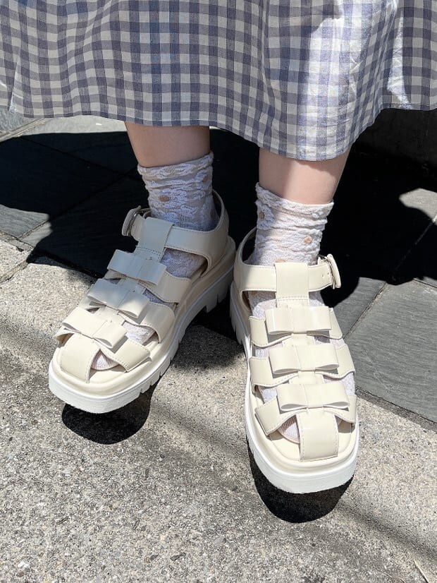 ホワイト系のサンダル、パープル系のハンドバッグ、パープル系のワンピースを着用したレディースの夏コーディネートの5枚目の写真