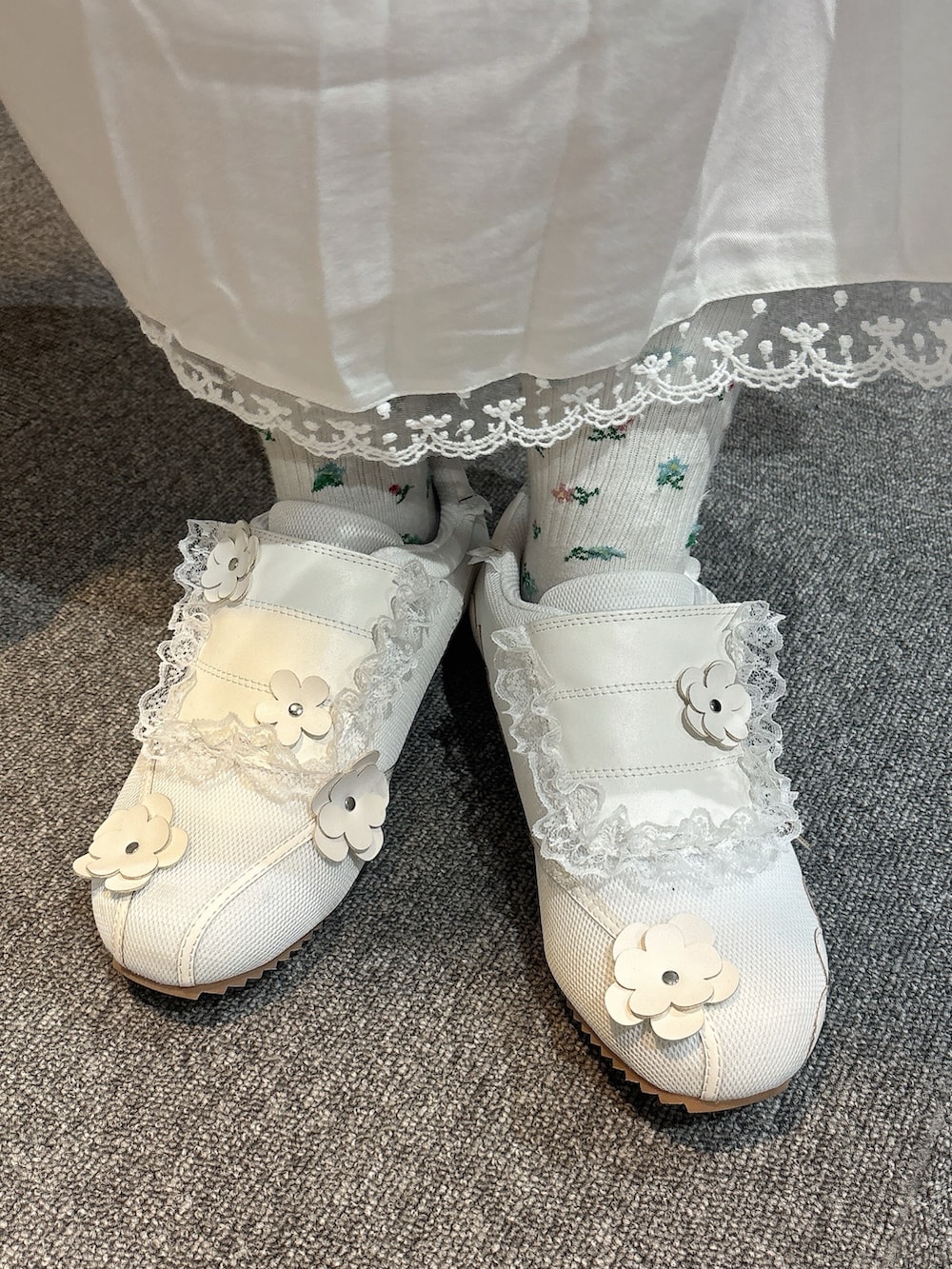 グリーン系のハンドバッグ、ホワイト系のスニーカー、ホワイト系のワンピースを着用したレディースの冬コーディネートの10枚目の写真