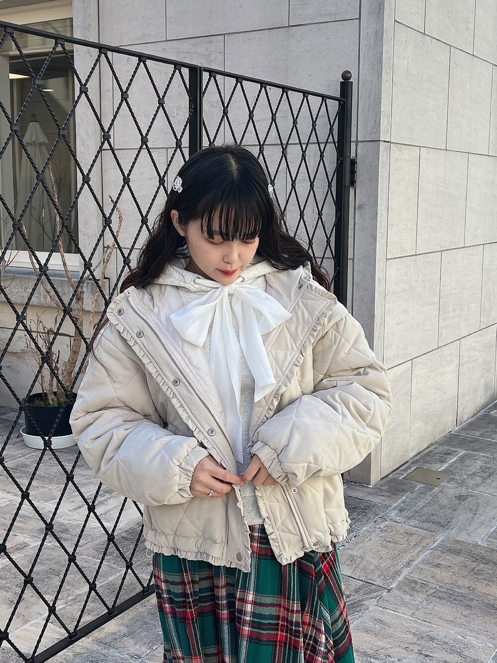 ホワイト系のパーカー、ホワイト系のその他アウター、グリーン系のスカートを着用したレディースの冬コーディネートの6枚目の写真