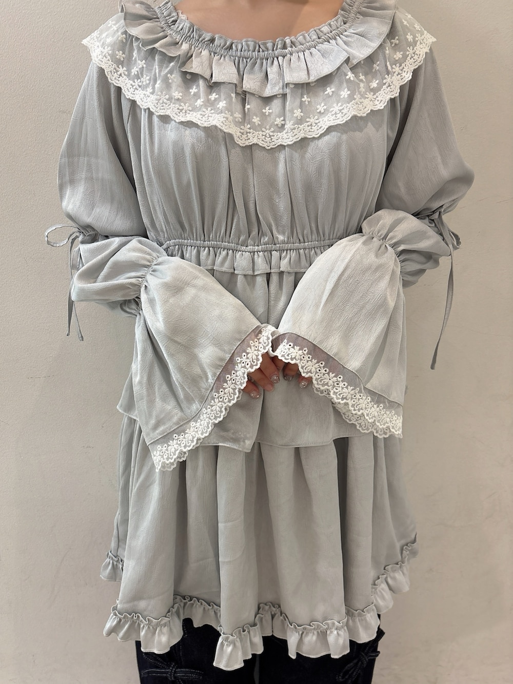ブルー系のワンピース、ブルー系のハンドバッグ、ブルー系のデニムパンツを着用したレディースの夏コーディネートの7枚目の写真