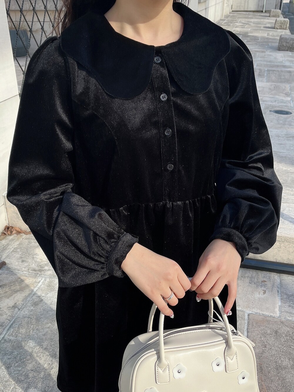 ブラック系のワンピース、ホワイト系のボストンバッグ、ブラック系のブーツを着用したレディースの冬コーディネートの6枚目の写真