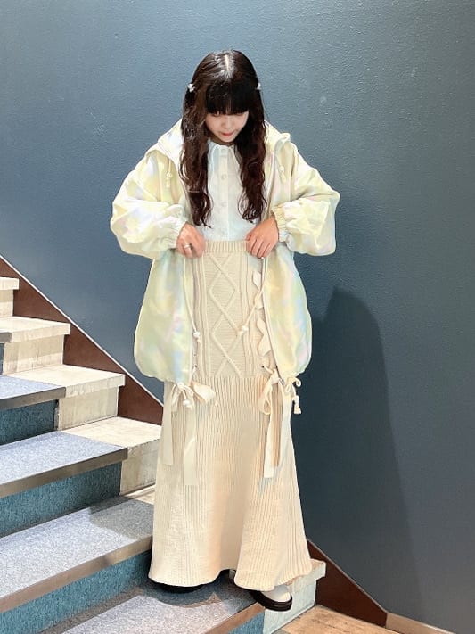 ホワイト系のブーツ、グリーン系のその他アウター、ホワイト系のスカートを着用したレディースの秋コーディネートの2枚目の写真