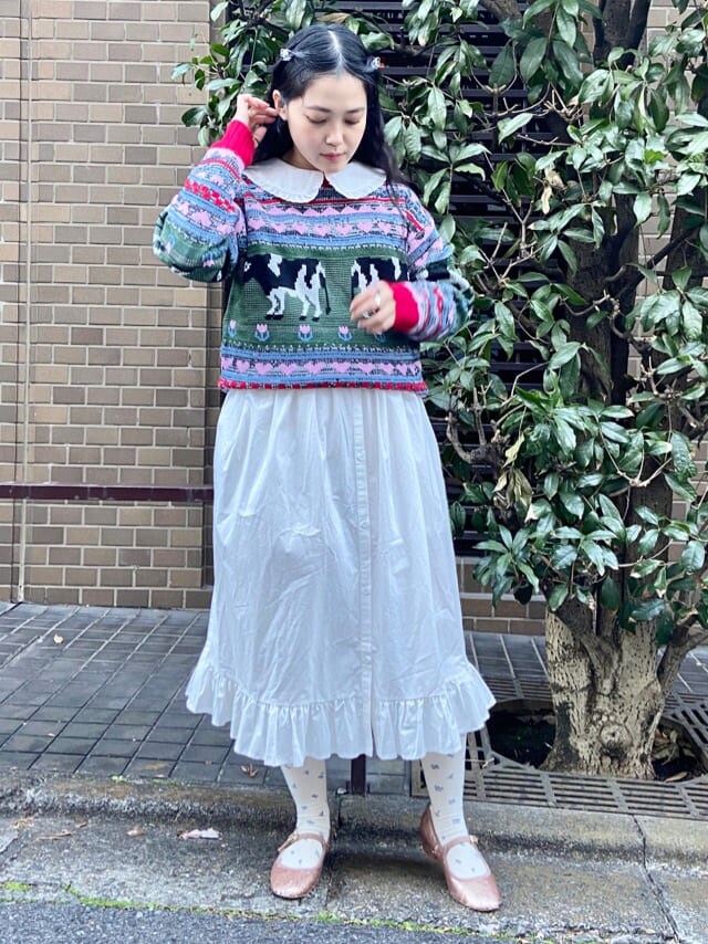 ベージュ系のパンプス、レッド系のニット/セーター、ホワイト系のワンピースを着用したレディースの冬コーディネートの2枚目の写真