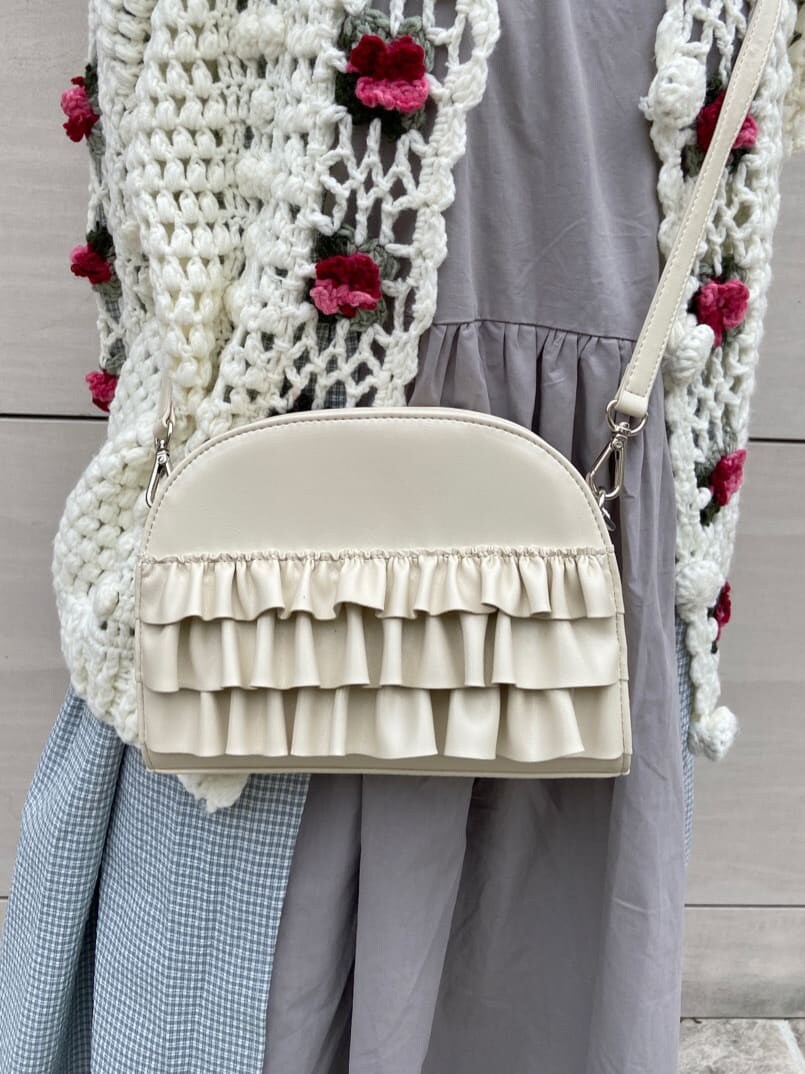 ホワイト系のカーディガン/ボレロ、ホワイト系のスニーカー、グレー系のワンピースを着用したレディースの冬コーディネートの6枚目の写真