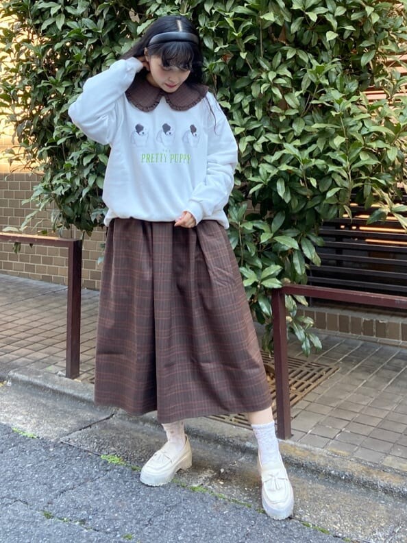 ブラウン系のカバーオール、ブラウン系のワンピース、ホワイト系のローファーを着用したレディースの冬コーディネートの6枚目の写真