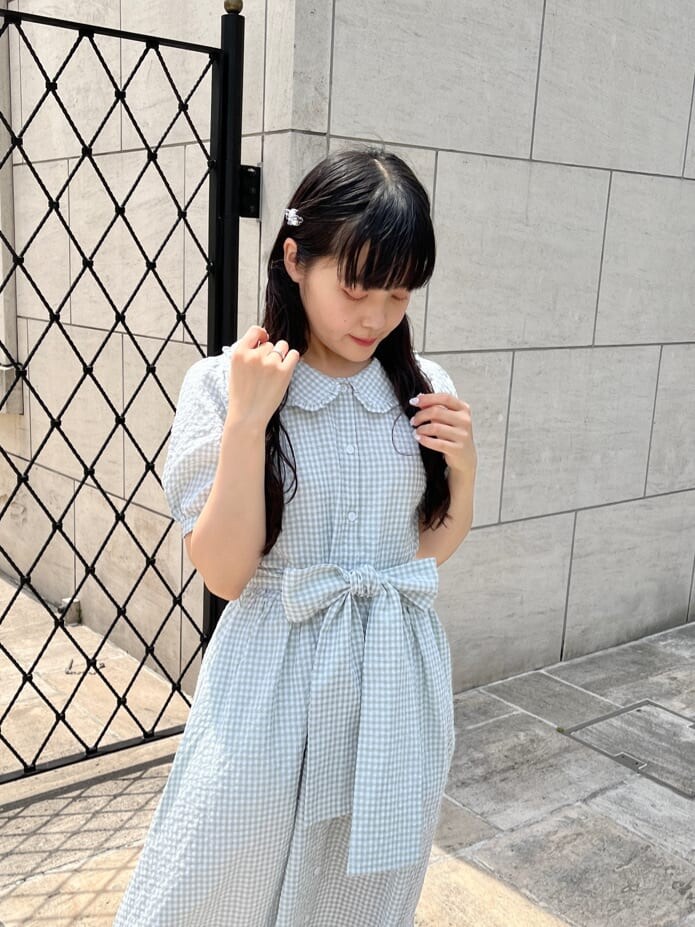 グリーン系のワンピース、ホワイト系のサンダル、ホワイト系のショルダーバッグを着用したレディースの春コーディネートの3枚目の写真