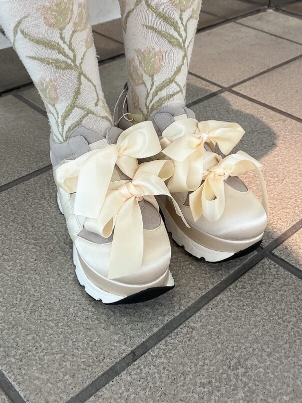 ホワイト系のスニーカー、ホワイト系のワンピース、ホワイト系のハンドバッグを着用したレディースの夏コーディネートの5枚目の写真