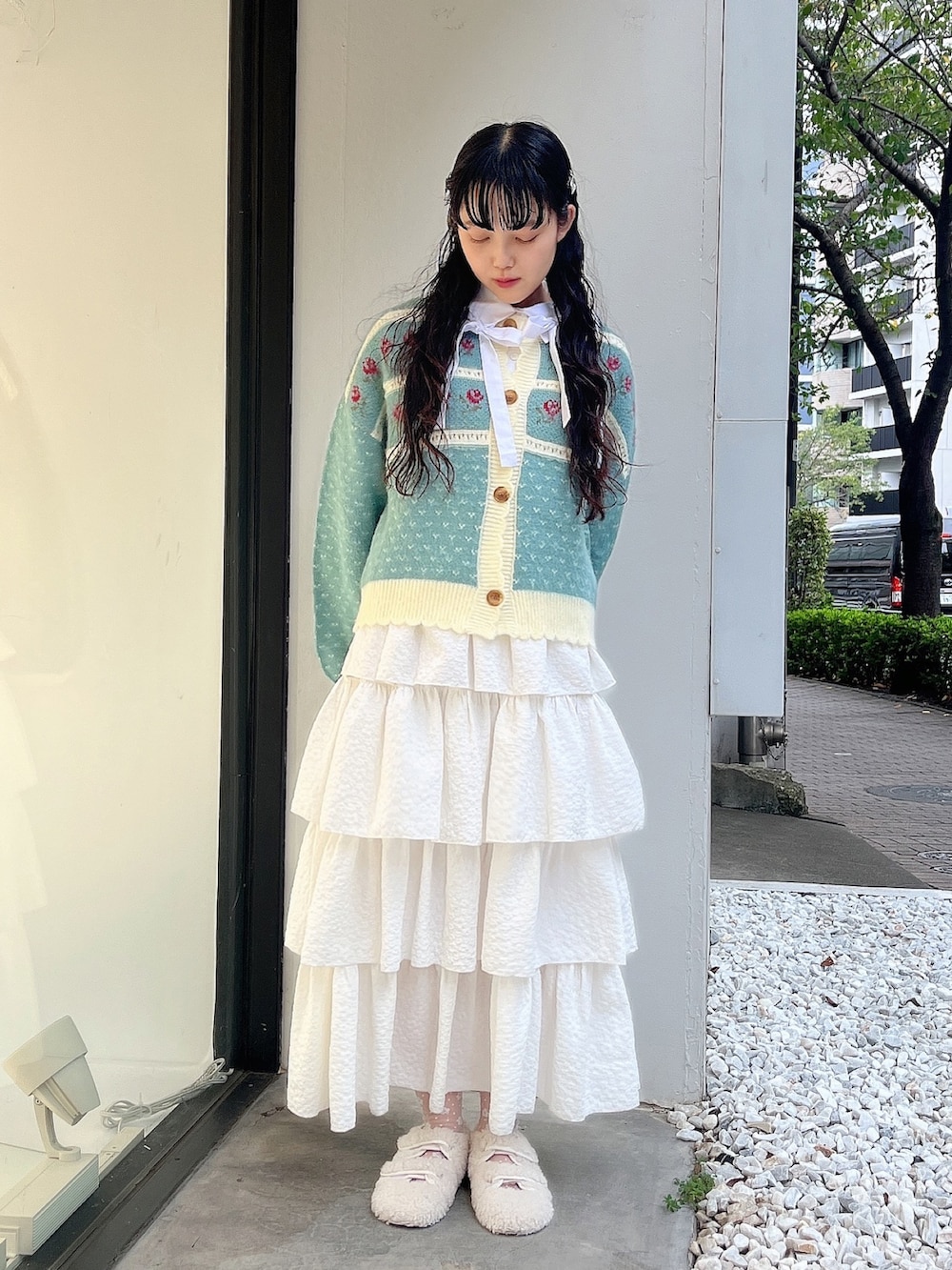 グリーン系のカーディガン/ボレロ、ホワイト系のシャツ/ブラウス、ホワイト系のスカートを着用したレディースの秋コーディネートの2枚目の写真