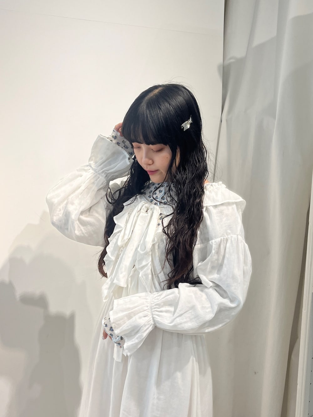 ブルー系のTシャツ/カットソー、ホワイト系のワンピース、ホワイト系のパンプスを着用したレディースの秋コーディネートの4枚目の写真