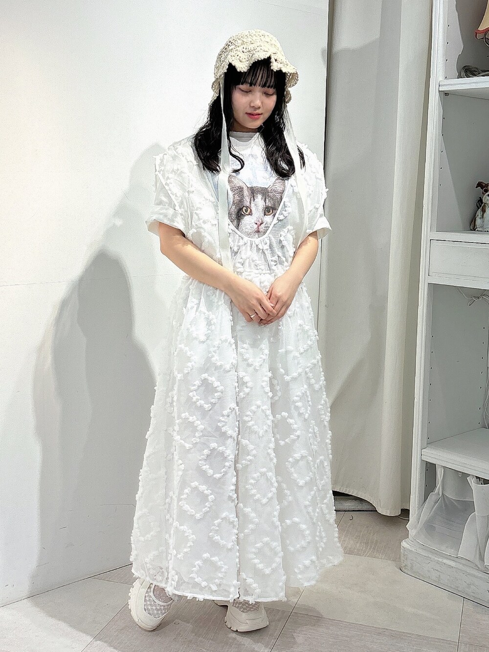 ホワイト系のTシャツ/カットソー、ホワイト系のジャンパースカート、ホワイト系のスニーカーを着用したレディースの春コーディネートの2枚目の写真