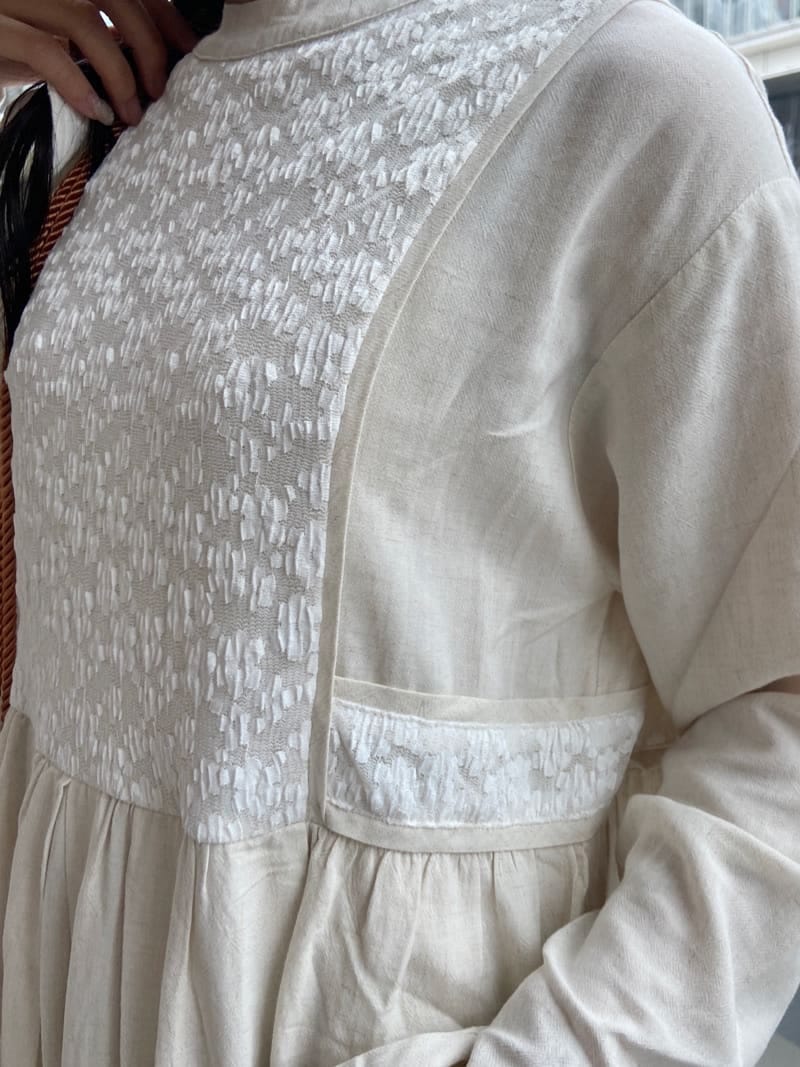 ホワイト系のテーラードジャケット、オレンジ系のハンドバッグ、ホワイト系のワンピースを着用したレディースの夏コーディネートの6枚目の写真