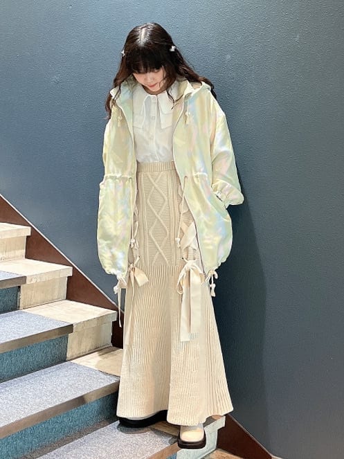 ホワイト系のブーツ、グリーン系のその他アウター、ホワイト系のスカートを着用したレディースの秋コーディネートの3枚目の写真