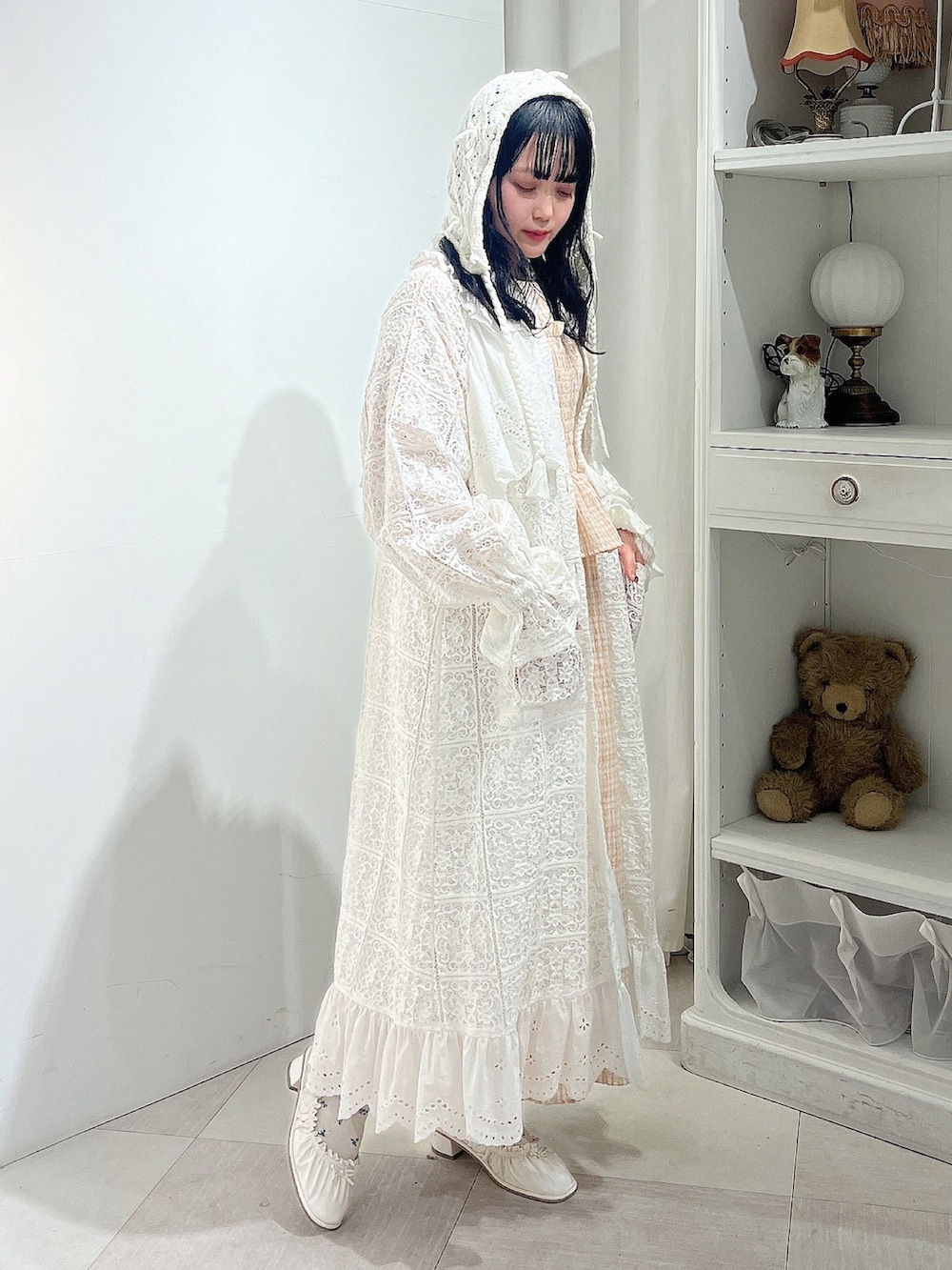 オレンジ系のワンピース、ホワイト系のトレンチコート、ホワイト系のパンプスを着用したレディースの春コーディネートの2枚目の写真