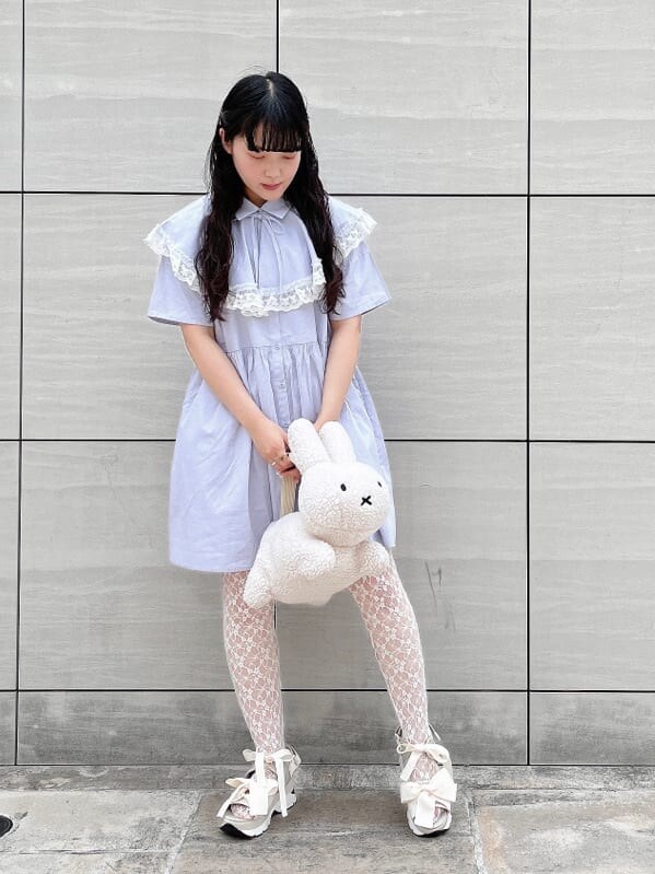 ホワイト系のサンダル、ホワイト系のハンドバッグ、ブルー系のワンピースを着用したレディースの夏コーディネートの2枚目の写真