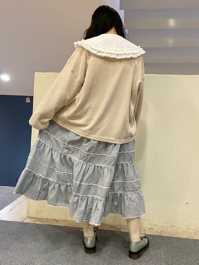 ブルー系のパンプス、ホワイト系のシャツ/ブラウス、ブルー系のスカートを着用したレディースの冬コーディネートの2枚目の写真