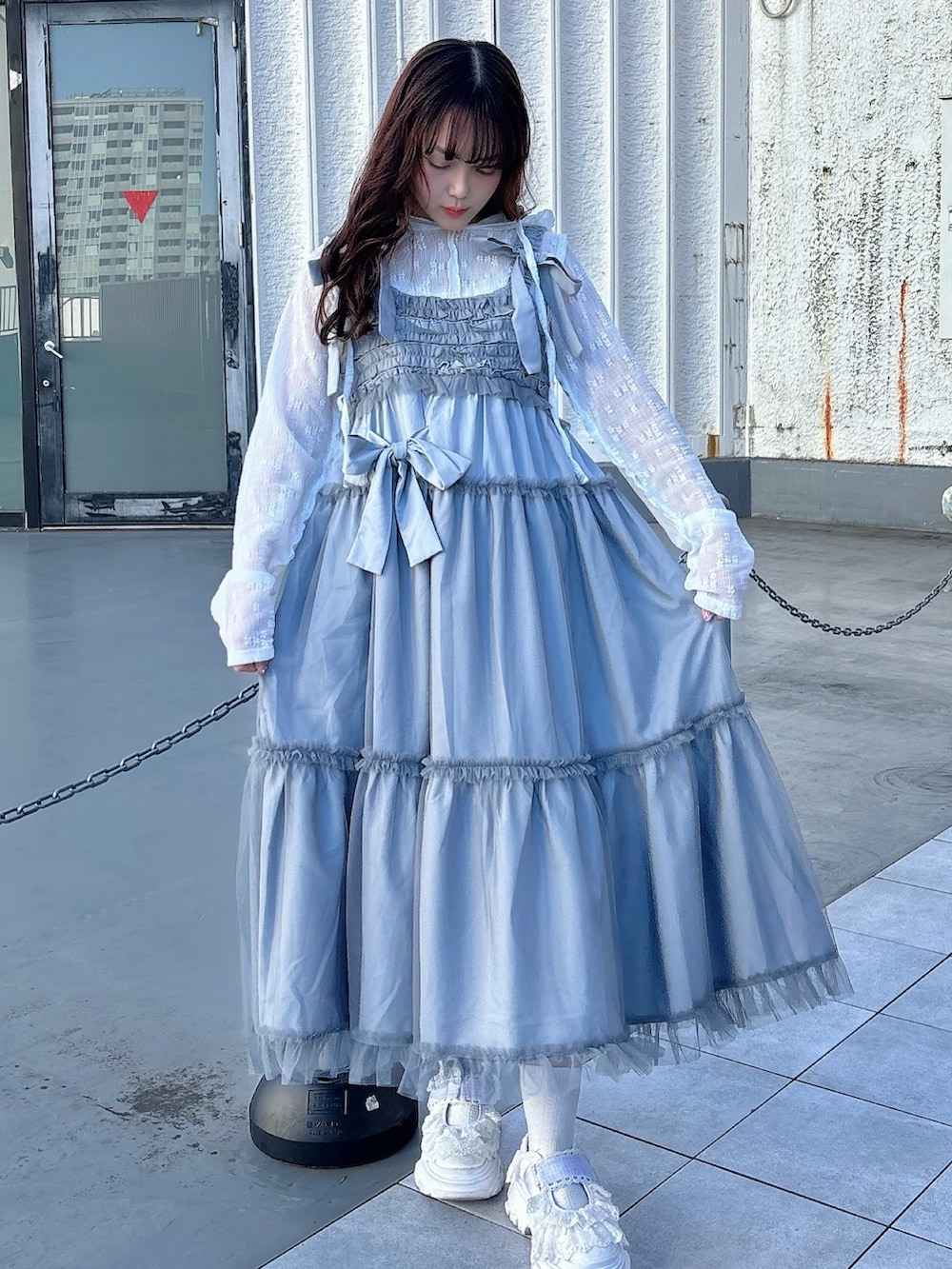 ホワイト系のTシャツ/カットソー、ブルー系のワンピース、ホワイト系のスニーカーを着用したレディースの冬コーディネートの2枚目の写真