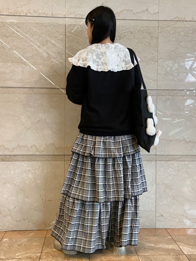 ブラック系のスカート、ブラック系のトートバッグ、ホワイト系のシャツ/ブラウスを着用したレディースの秋コーディネートの2枚目の写真