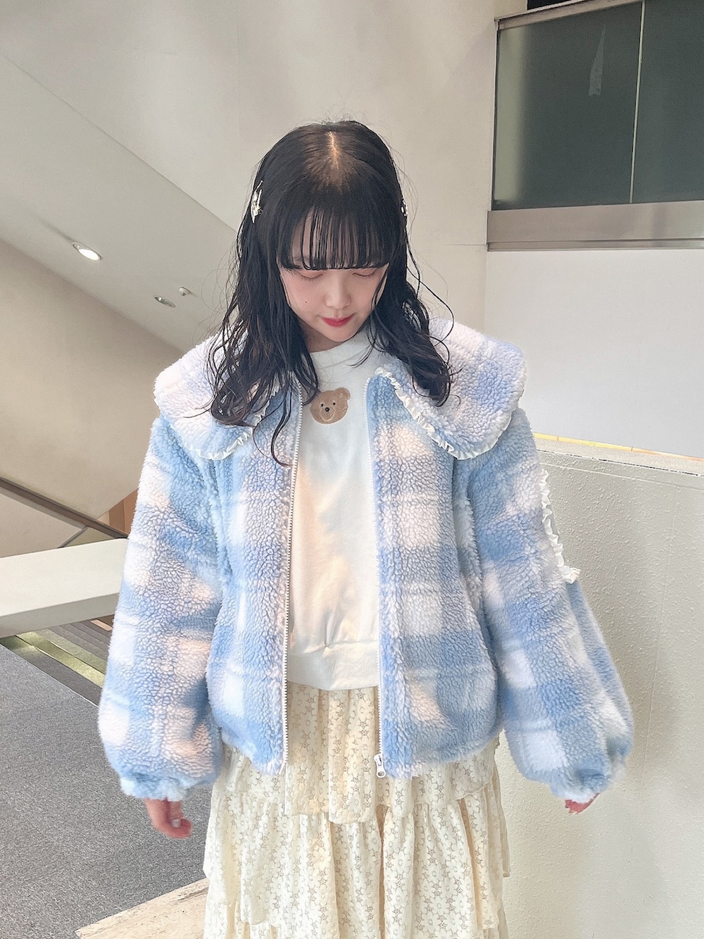 ホワイト系のスウェット、ブルー系のブルゾン、ホワイト系のスカートを着用したレディースの冬コーディネートの3枚目の写真