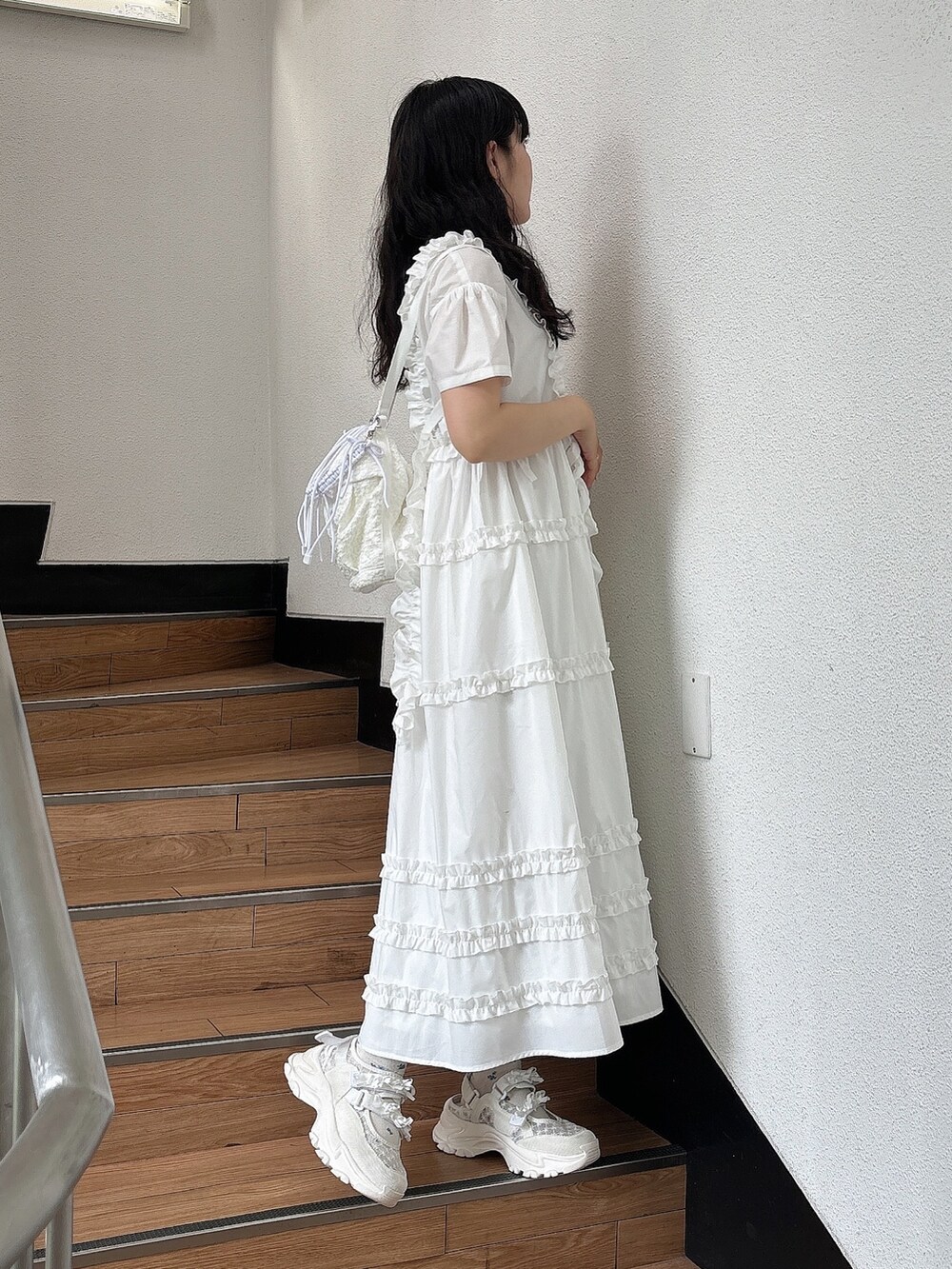 ホワイト系のスニーカー、ホワイト系のワンピース、ホワイト系のショルダーバッグを着用したレディースの夏コーディネートの4枚目の写真