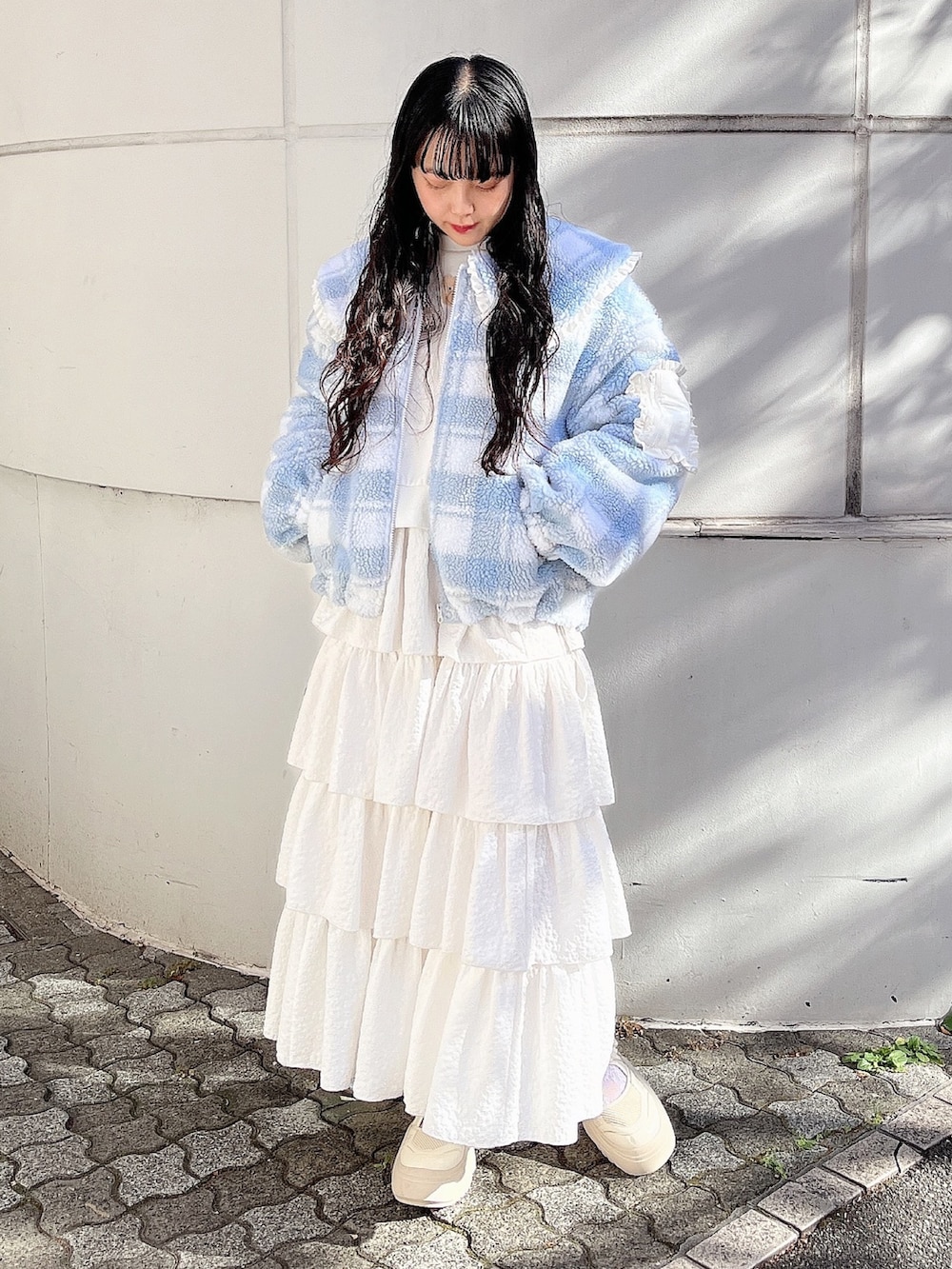ホワイト系のスウェット、ブルー系のブルゾン、ホワイト系のスカートを着用したレディースの冬コーディネートの2枚目の写真