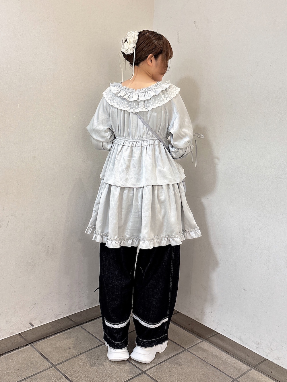 ブルー系のワンピース、ブルー系のハンドバッグ、ブルー系のデニムパンツを着用したレディースの夏コーディネートの4枚目の写真