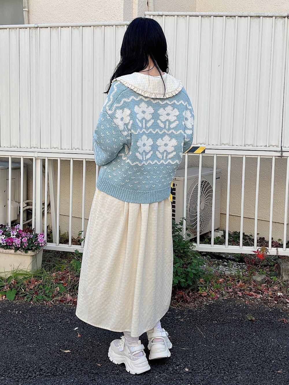 イエロー系のワンピース、ブルー系のカーディガン/ボレロ、ホワイト系のスニーカーを着用したレディースの冬コーディネートの3枚目の写真