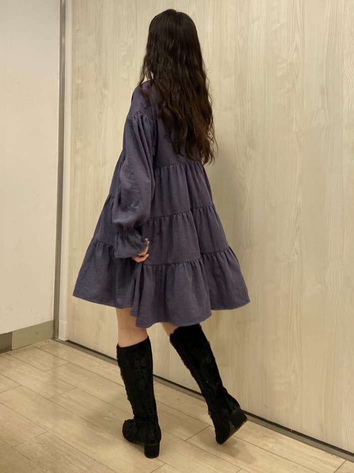 ブルー系のナイロンジャケット、パープル系のワンピース、ブラック系のブーツを着用したレディースの冬コーディネートの4枚目の写真