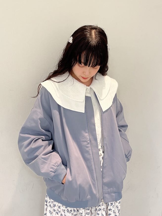 ホワイト系のパンプス、ホワイト系のスカート、ブルー系のブルゾンを着用したレディースの秋コーディネートの4枚目の写真