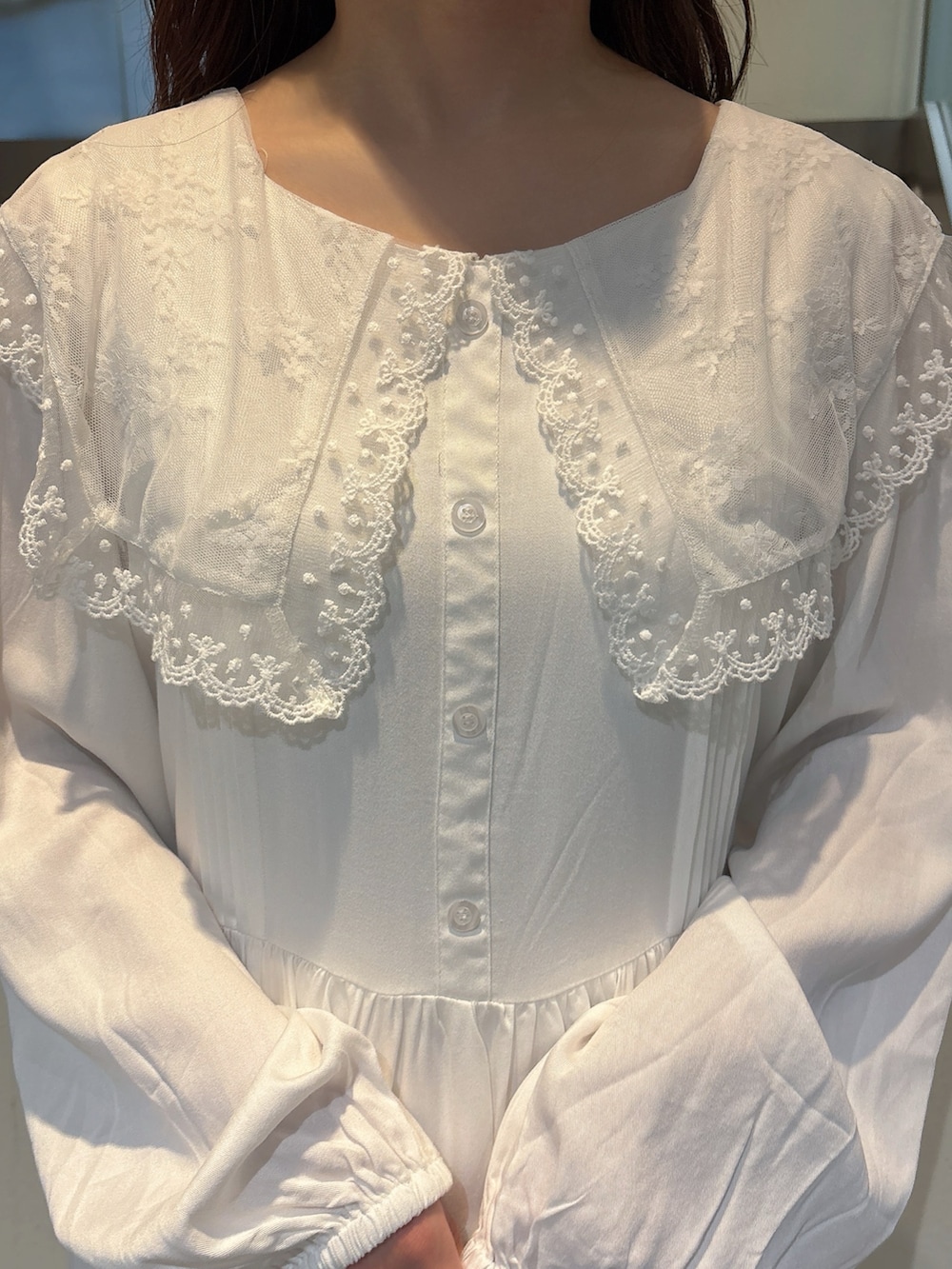 グリーン系のハンドバッグ、ホワイト系のスニーカー、ホワイト系のワンピースを着用したレディースの冬コーディネートの8枚目の写真